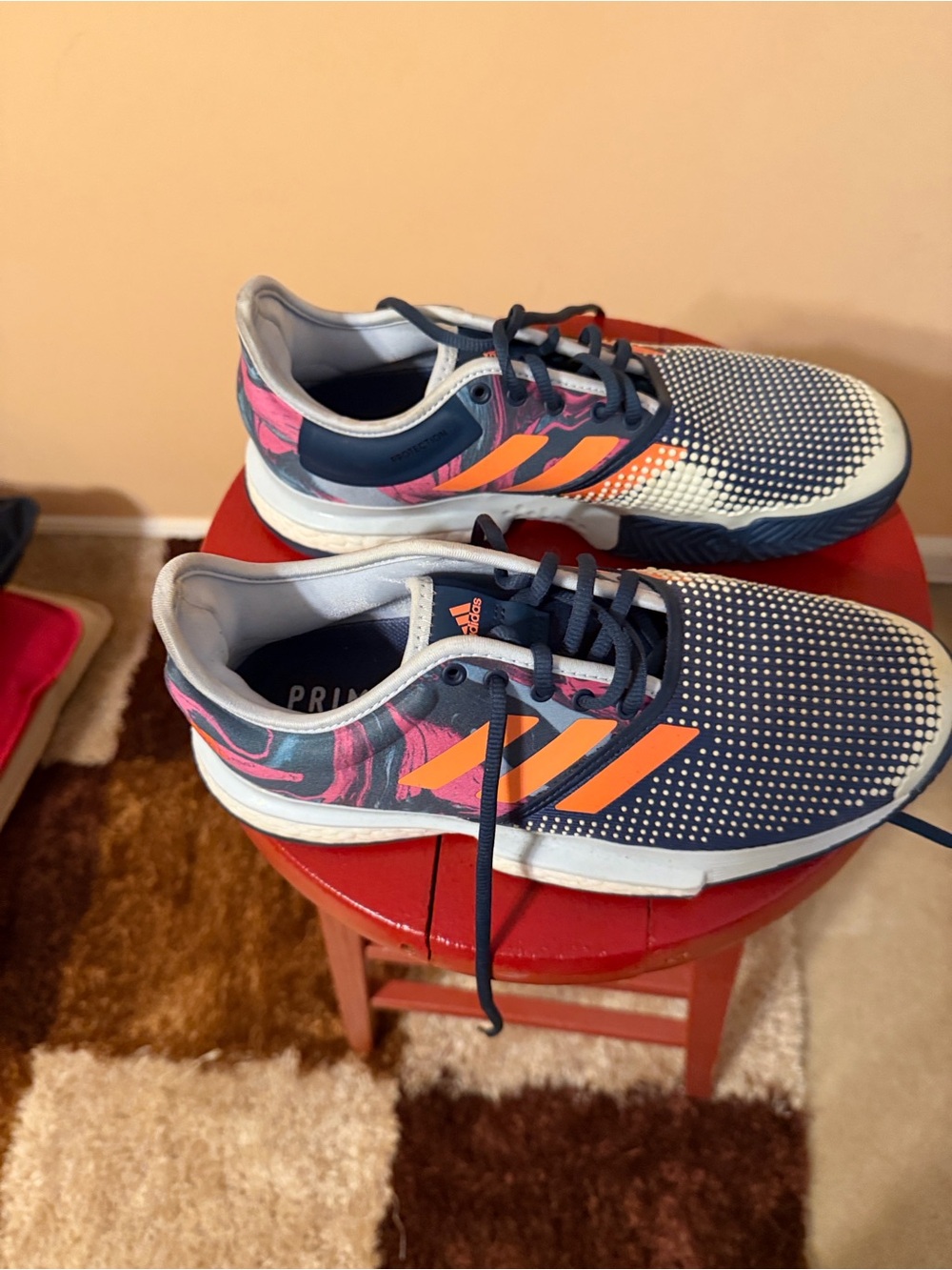 adidas navy athletic sneakers with orange stripes and pink accents